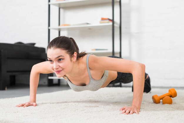 Fille faisant des exercices de flexion dans sa maison