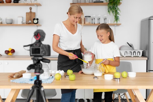 Fille et femme faisant de la nourriture coup moyen