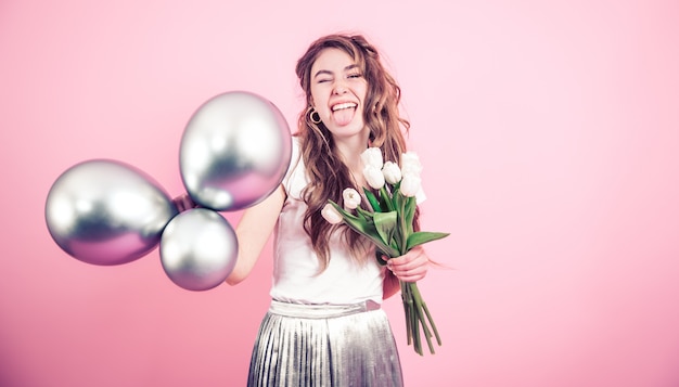 Fille avec des fleurs et des boules sur un mur coloré