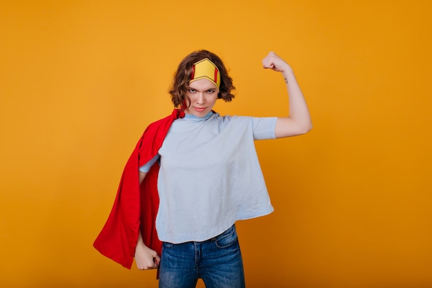 Fille forte en couronne montrant les muscles