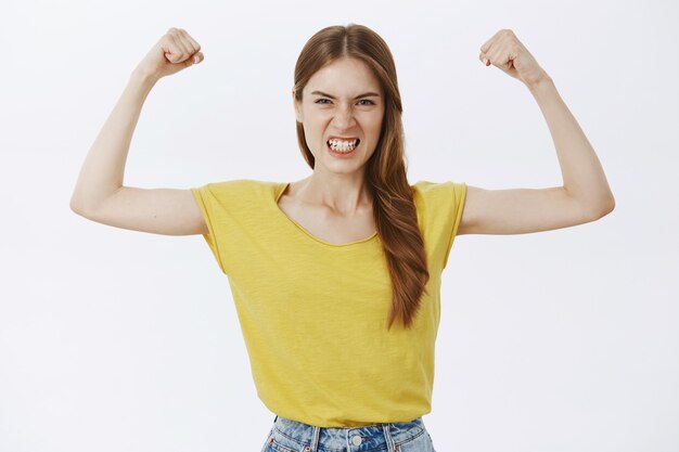 Fille forte et puissante fléchissant les biceps, montrant sa force