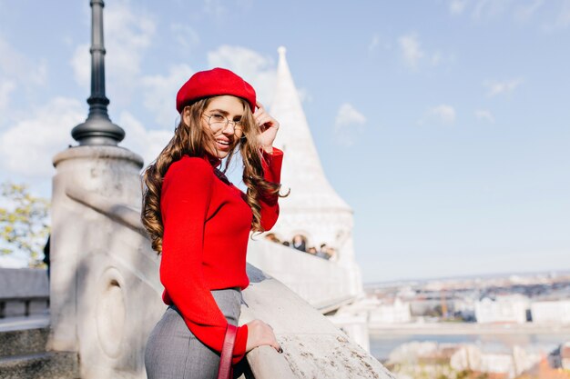 Fille française bien habillée dans des verres bénéficiant d'une vue sur la ville en journée ensoleillée