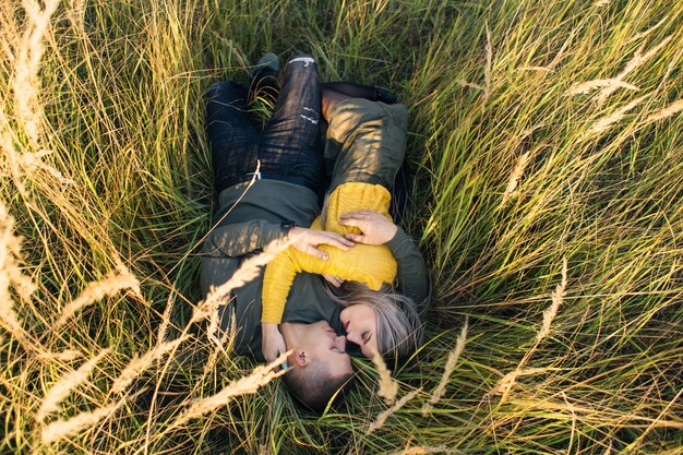 La fille et le garçon embrassant et couché sur l&#39;herbe