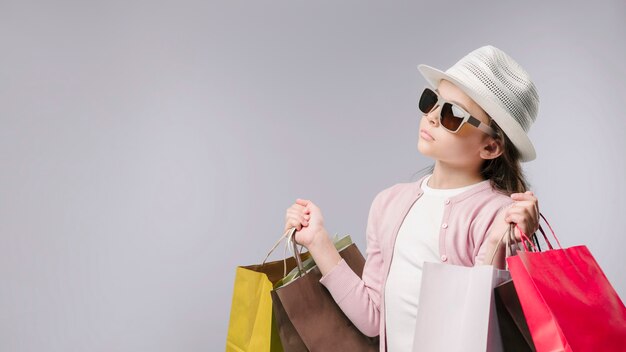 Fille glamour avec des sacs à provisions en studio