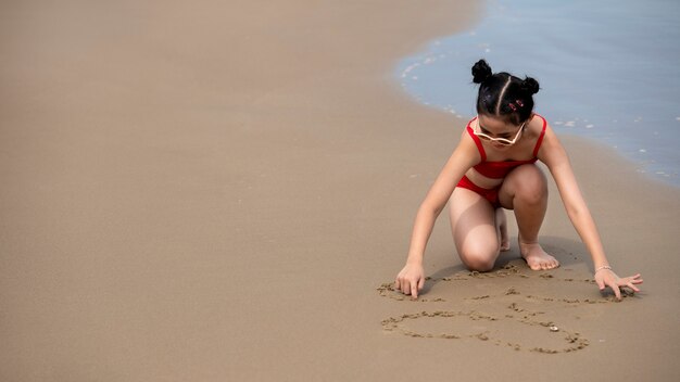 Fille grand angle jouant sur le sable