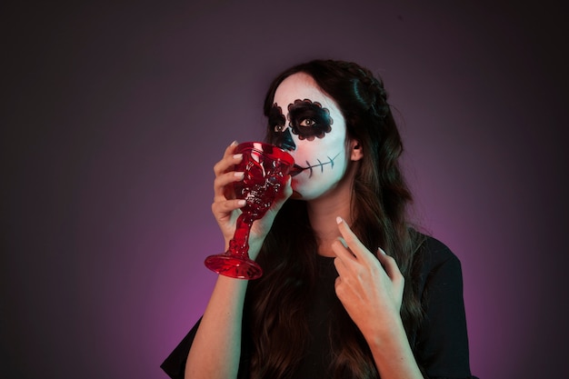 Photo gratuite fille halloween buvant à la tasse