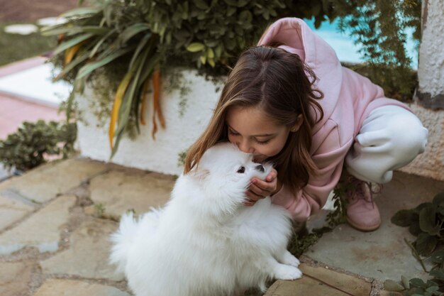 Fille de haute vue embrassant son chien