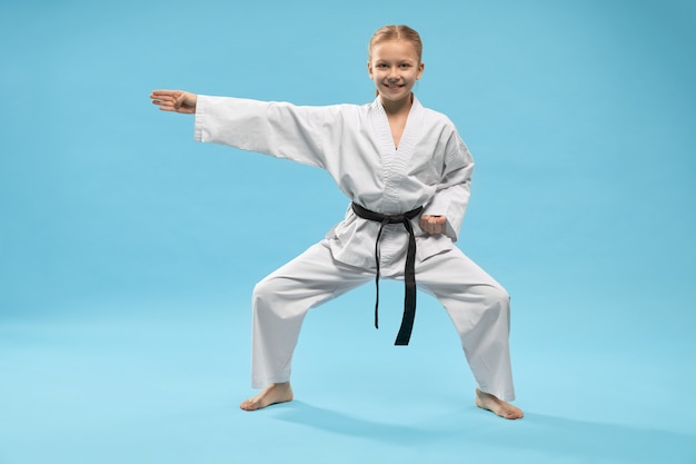 Fille heureuse en kimono blanc debout en position universelle