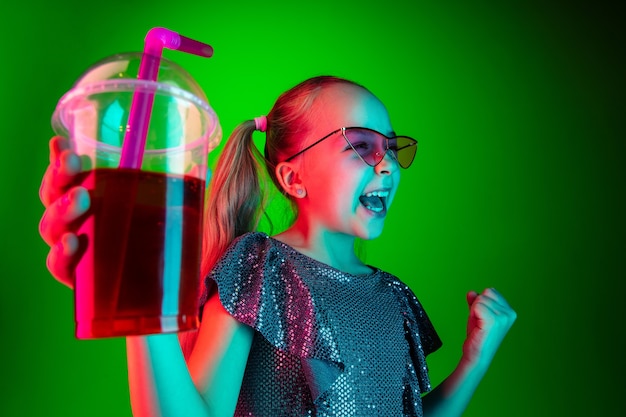 Fille heureuse avec des lunettes de soleil tenant du jus