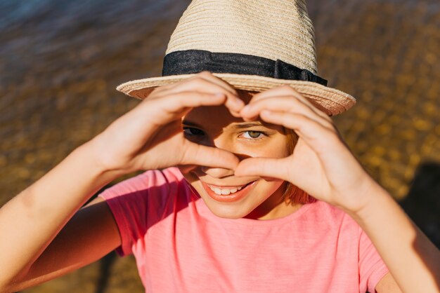 Fille heureuse, montrant le coeur avec les mains