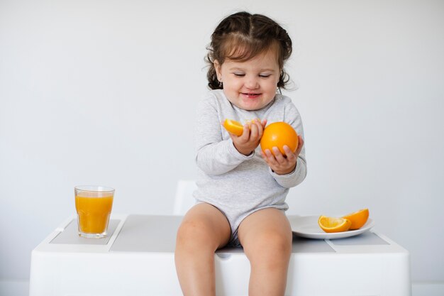 Fille heureuse en regardant ses oranges