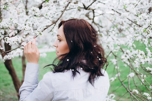 La fille heureuse se tient dans le parc