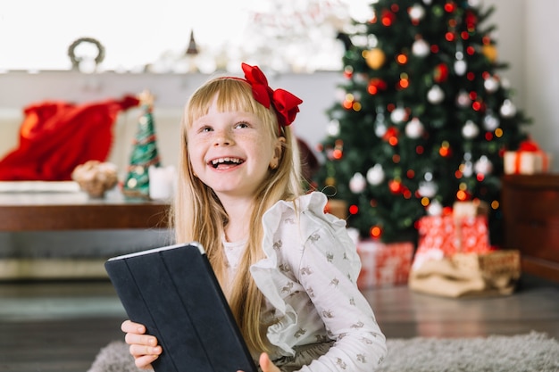 Photo gratuite fille heureuse avec tablette à noël