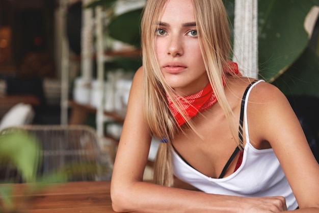 Photo gratuite fille de hipster avec bandana sur le cou pose au café
