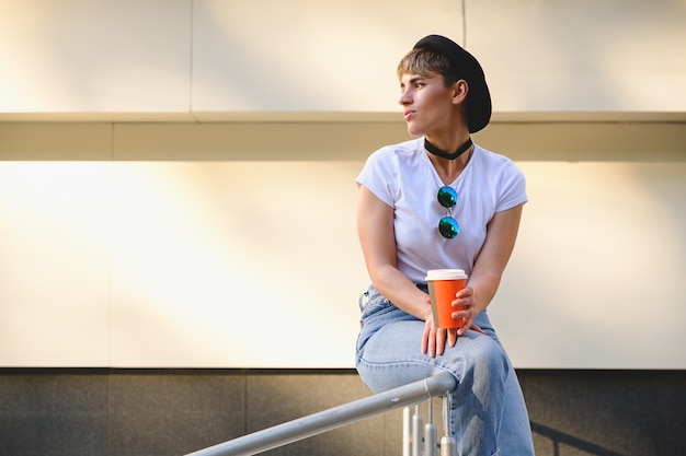 Fille de hipster boire du café pour aller