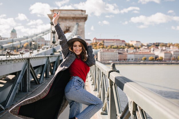 Fille insouciante en blue-jeans danse heureuse sur fond d'architecture