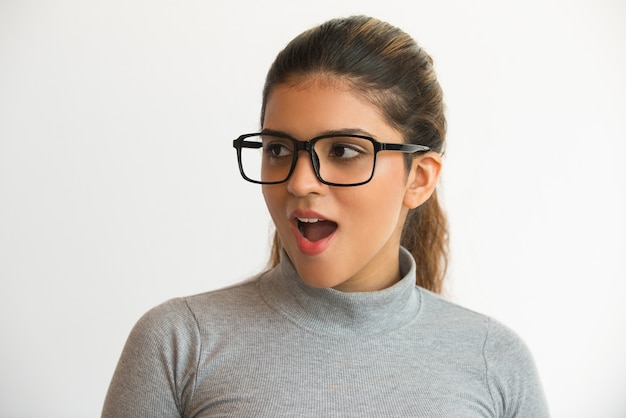 Photo gratuite une fille intelligente excitée qui ouvre la bouche et regarde loin