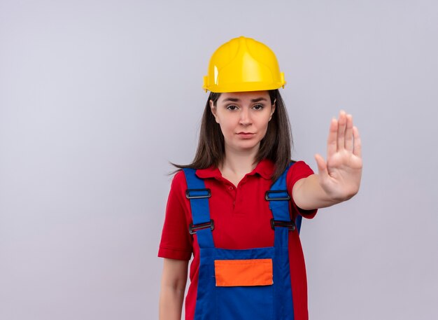 Fille jeune constructeur agacé montre le geste d'arrêt sur fond blanc isolé avec copie espace