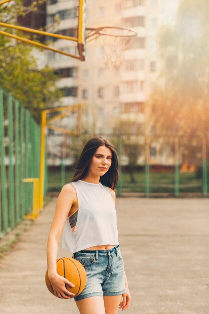 Fille jouant au basketball en milieu urbain