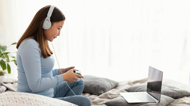 Fille jouant au jeu vidéo avec des écouteurs