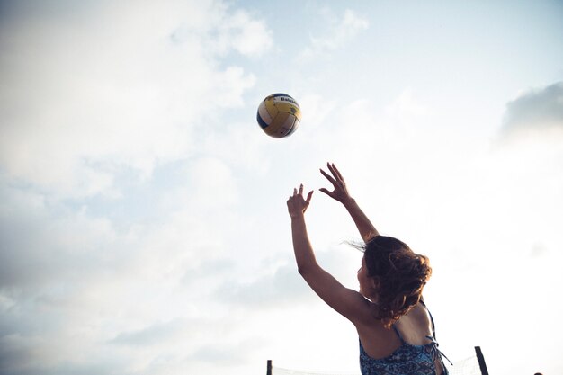 Fille jouant au volleyball à la plage