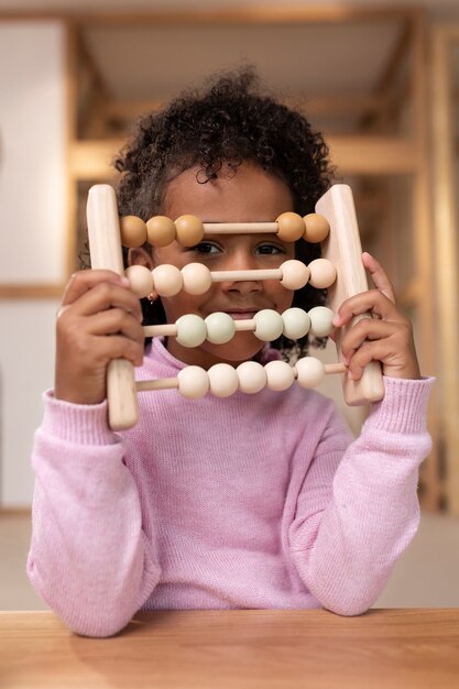 Fille jouant avec des jouets écologiques vue de face