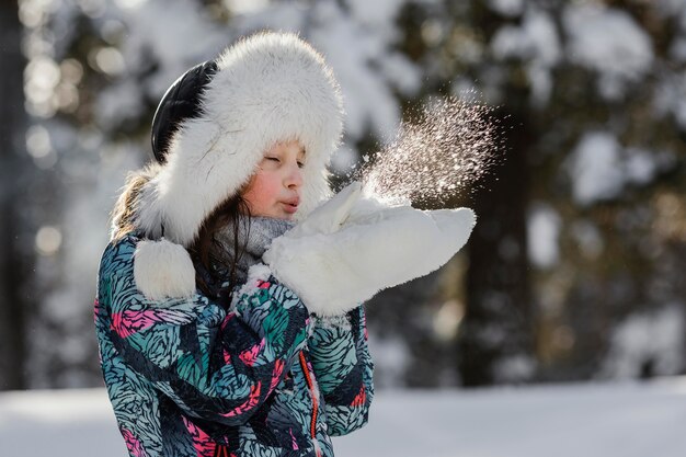 Fille jouant avec de la neige en plein air coup moyen