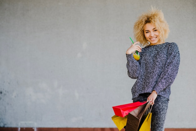 Fille joyeuse avec des boissons et des achats