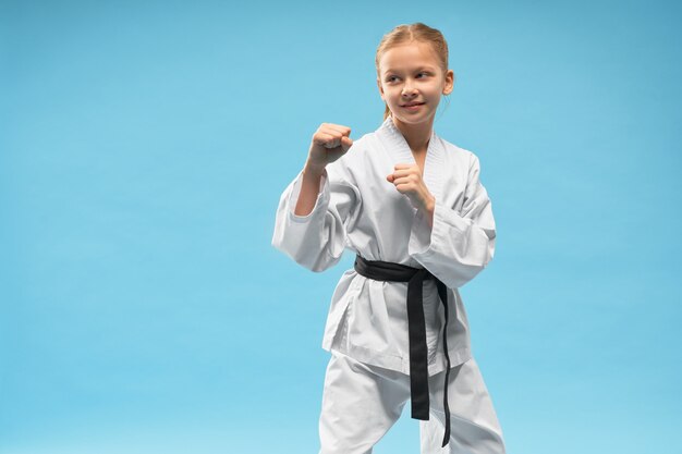 Fille de karaté en position de défense, pratiquant des sports de combat.