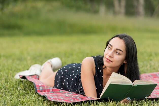 Fille lisant sur une couverture de pique-nique