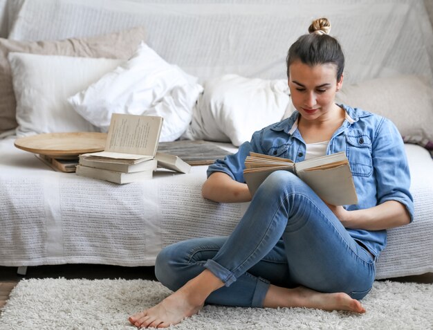 fille lisant un livre dans une chambre confortable