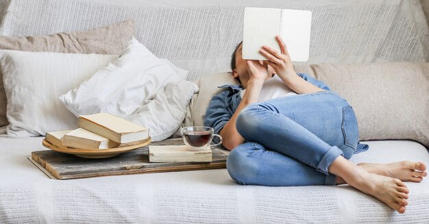 fille lisant un livre dans une chambre confortable