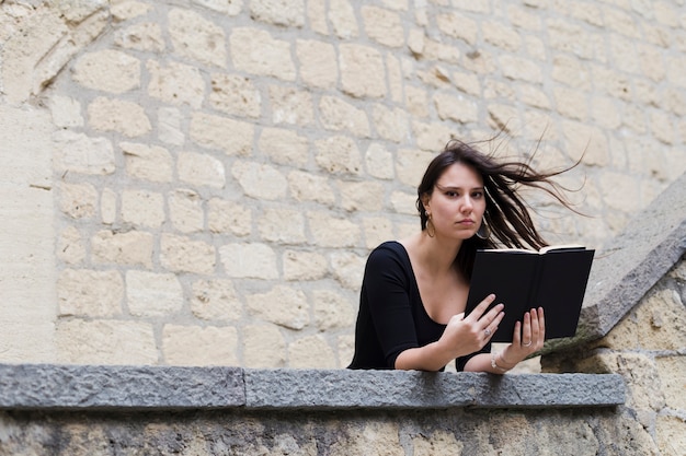 Fille lisant un livre dans une journée venteuse