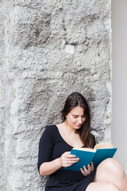 Fille lisant un livre dans la rue