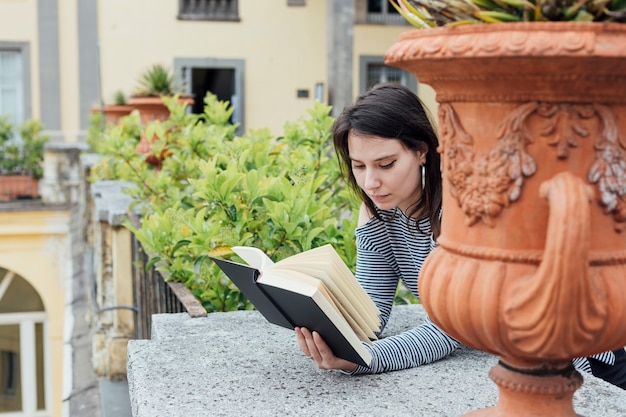 Fille lisant un livre dans la rue