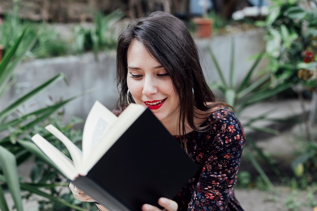 Photo gratuite fille lisant un livre dans la rue