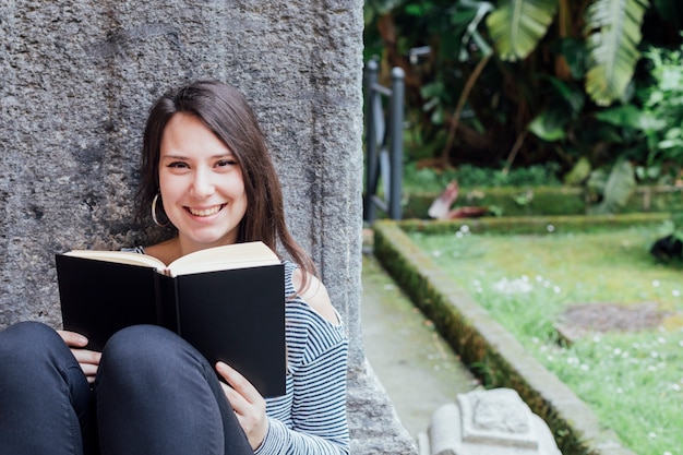 Photo gratuite fille lisant un livre dans la rue