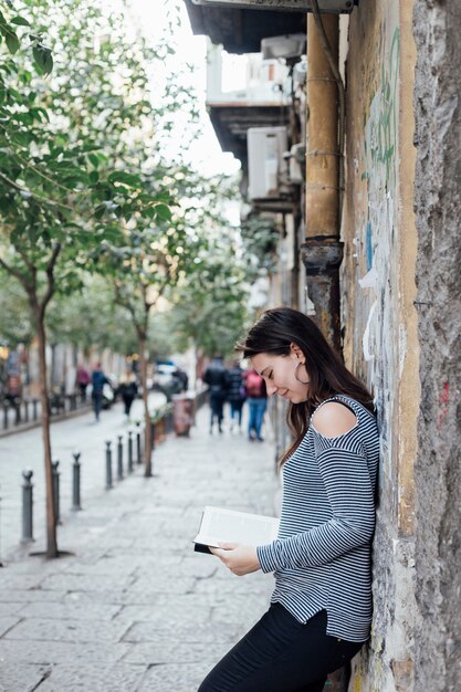 Fille lisant un livre dans la rue