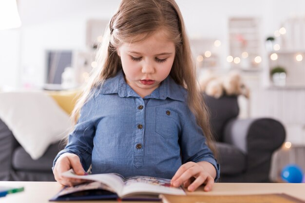 Fille lisant un livre dans le salon