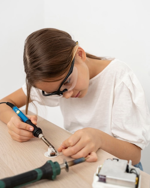 Fille avec des lunettes de protection faisant des expériences scientifiques