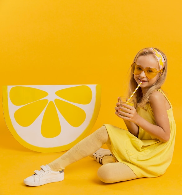 Photo gratuite fille avec des lunettes de soleil posant avec une décoration de tranche de citron