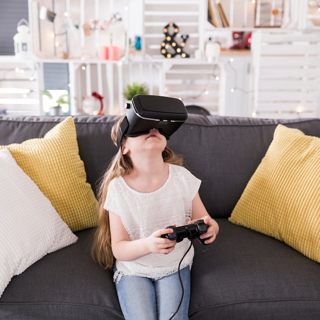 Fille avec des lunettes VR sur le canapé
