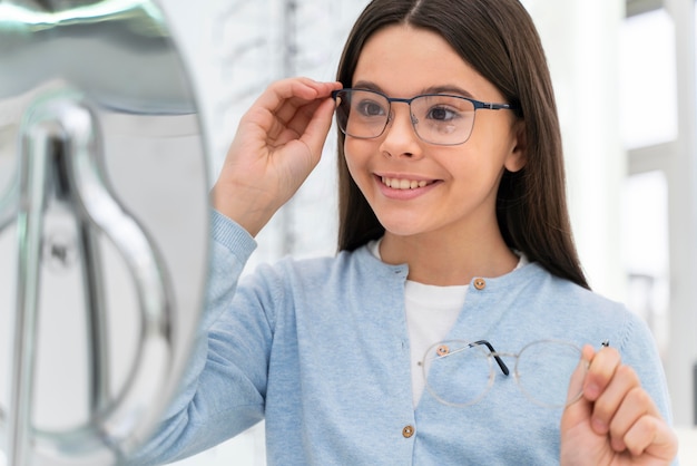 Fille en magasin essayant des lunettes