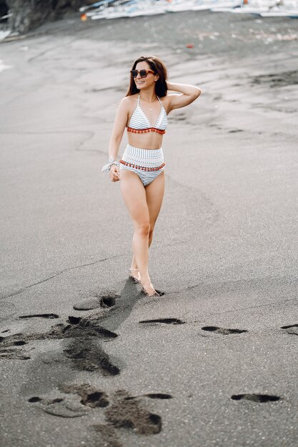 Fille en maillot de bain élégant se reposer sur une plage na