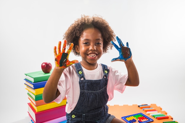 Fille avec des mains colorées avec de la peinture en studio