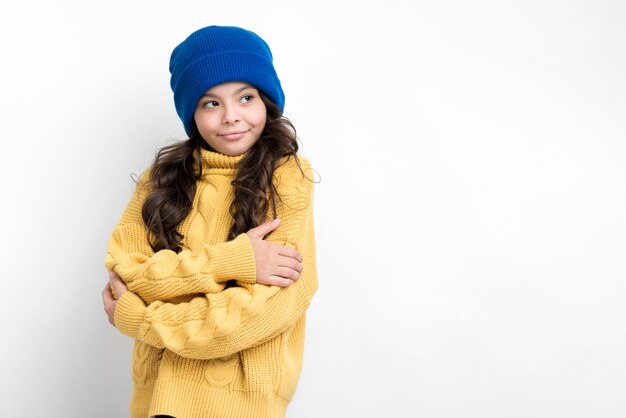 Fille avec les mains jointes à la poitrine, regardant à gauche