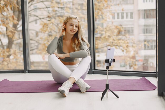 Fille à la maison. Femme fait du yoga. Lady tourne un blog vidéo.