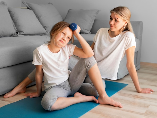 Fille et maman s'entraînant à la maison