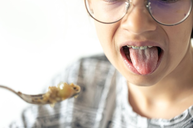 Une fille mange du porridge avec des fruits en gros plan