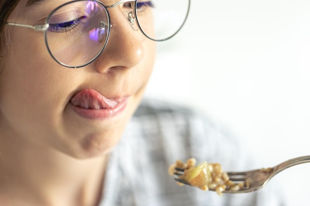 Une fille mange du porridge avec des fruits en gros plan